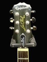 Guitar headstock with Epiphone Les Paul branding on a dark background