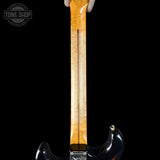 Close-up of a guitar neck with a black background, featuring the 'Tone Shop' logo.
