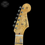Close-up of a Fender Stratocaster guitar headstock on a black background with 'Tone Shop' logo.