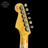 Close-up of a guitar headstock with tuning pegs on a black background, featuring the Tone Shop logo.