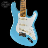 Blue electric guitar with a white pickguard on a black background, featuring 'Tone Shop' branding.