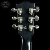 Guitar headstock with tuning pegs on a black background, featuring the Tone Shop logo.
