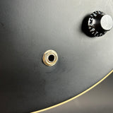 Close-up of a skateboard truck with a black wheel and gold bearing.