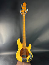 Yellow bass guitar on a dark gray background
