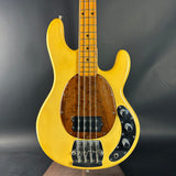 Yellow electric bass guitar on a dark gray background