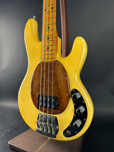 Yellow electric bass guitar on a dark background
