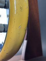 Close-up of a yellow wheel with visible wear and tear on a blurred background