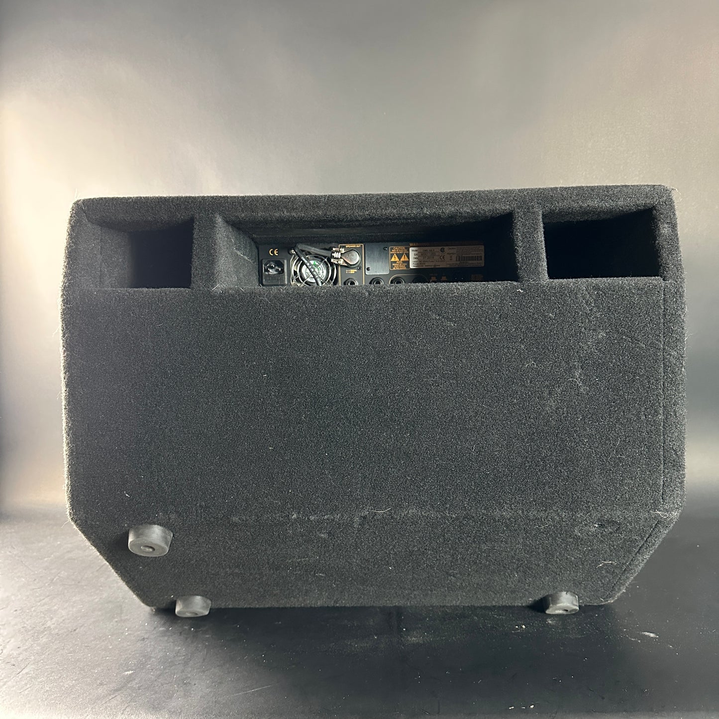Black speaker enclosure with electronic components on a gray background