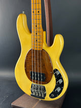 Yellow electric bass guitar on a dark background