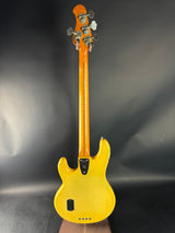 Yellow electric bass guitar on a dark background