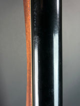 Close-up of a rifle barrel with a wooden grip on a gray background