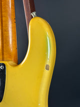 Close-up of a yellow guitar neck with a dark background