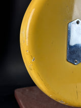 Close-up of a yellow object with a metallic plate on a dark background