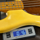 Yellow electric guitar on a digital scale displaying weight