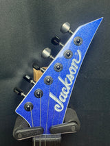 Blue and silver Jackson guitar headstock on a black background
