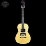 Acoustic guitar with a visible brand logo on a black background
