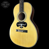 Acoustic guitar with a bull logo on a black background, featuring the Tone Shop logo.