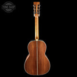 Back view of a wooden acoustic guitar with 'Tone Shop' logo in the corner.