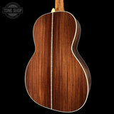 Back view of a wooden acoustic guitar with 'Tone Shop' logo in the corner.