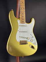 Gold electric guitar with a dark background