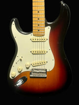 Electric guitar with a sunburst finish on a dark background