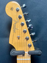 Guitar headstock with Fender logo on a dark background