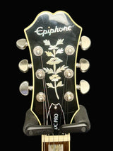 Epiphone guitar headstock with floral design on a dark background