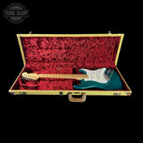 Teal electric guitar in a red-lined case with 'Tone Shop' logo.