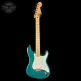 Teal electric guitar with a white pickguard on a black background, featuring 'Tone Shop' logo.