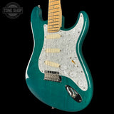 Teal electric guitar with a close-up view on a black background, featuring the 'Tone Shop' logo.