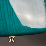Close-up of teal yarn on a spool with a metal bobbin.