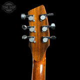 Close-up of a guitar headstock with tuning pegs on a black background, featuring the Tone Shop logo.