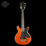 Electric guitar with a black pickguard on a black background, featuring the Gibson logo.