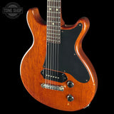 Electric guitar with a glossy finish on a black background, featuring the Tone Shop logo.