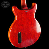 Red electric guitar body with a visible brand logo in the corner.