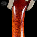 Close-up of a guitar neck with a 'Tone Shop' logo in the corner.