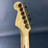 Guitar headstock with tuning pegs on a dark blue background