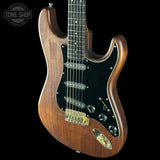 Wooden electric guitar with a visible brand logo on a black background