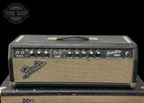 A vintage Fender Tremolo amp head amplifier resting on its matching speaker cabinet, photographed against a solid black background. The amp head features a black textured top and a beige tweed grille with silver controls and knobs.