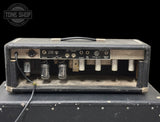 A vintage black tube amplifier head resting on a matching black speaker cabinet against a solid black background, with a Tone Shop watermark in the top left corner.