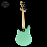 Green electric guitar on a black background with 'Tone Shop' logo.