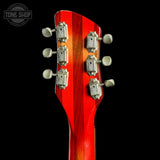 Close-up of the headstock of a guitar with a glossy red and orange sunburst finish, featuring six silver tuning pegs, set against a solid black background.