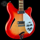 A Rickenstock electric guitar with a red and orange sunburst finish, featuring a white pickguard, chrome hardware, and a maple neck, shown against a black background.