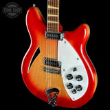 A classic electric guitar with a red and orange sunburst finish, a white pickguard, and chrome hardware, shown against a solid black background with a Tone Shop watermark in the top left corner.