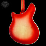 Close-up of the back of an electric guitar body with a red sunburst finish, showing the natural wood grain and a white binding edge, set against a black background with a Tone Shop watermark in the top left.