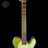 A close-up of an electric guitar neck and lower body against a solid black background. The guitar features a light green glitter finish on the body, a dark brown maple fretboard with gold dot inlays, and a white pickguard.