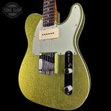 A gold glitter electric guitar with a cream pickguard and black control plate, shown against a solid black background with a Tone Shop watermark in the top-left corner.