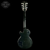 Back view of a black electric guitar with 'Tone Shop' logo.