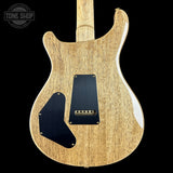 Back view of a wooden electric guitar with a black pickguard on a black background, featuring 'Tone Shop' branding.