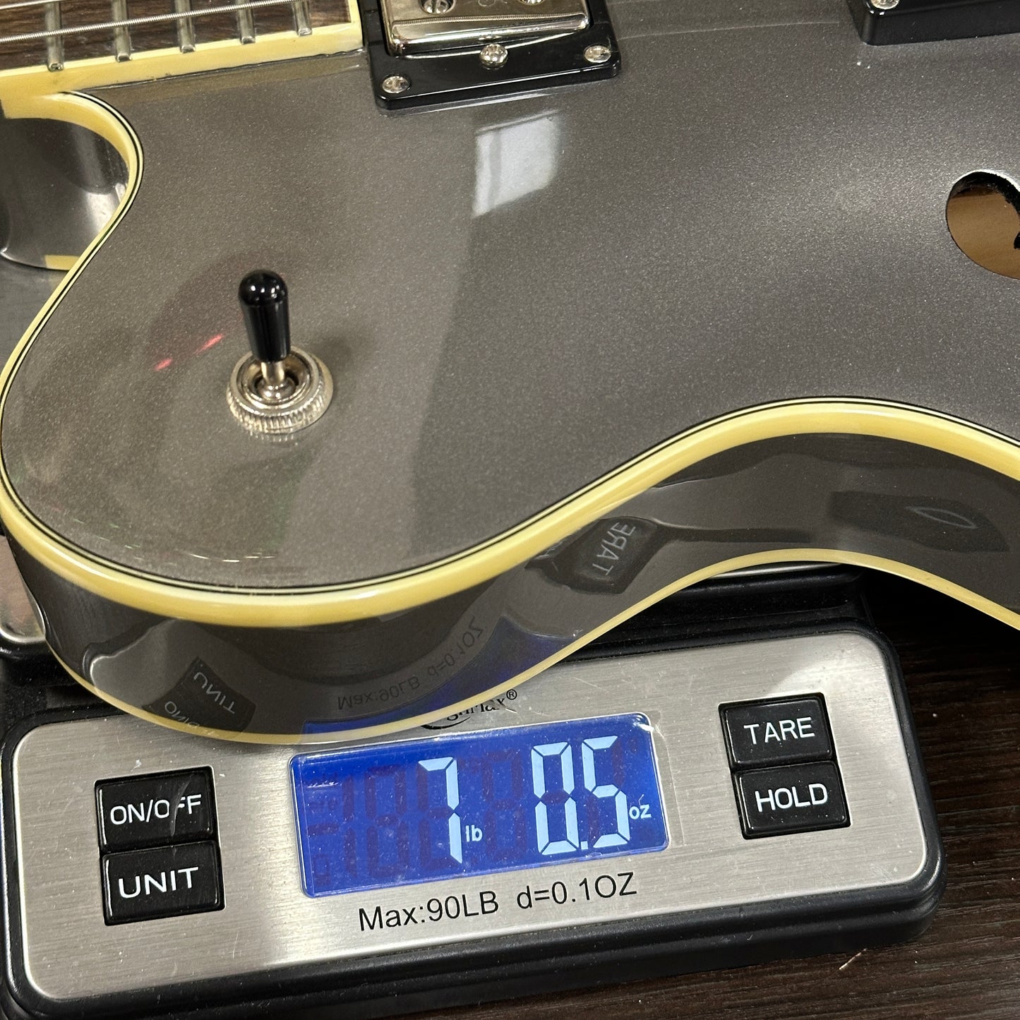 Guitar on a digital scale displaying weight